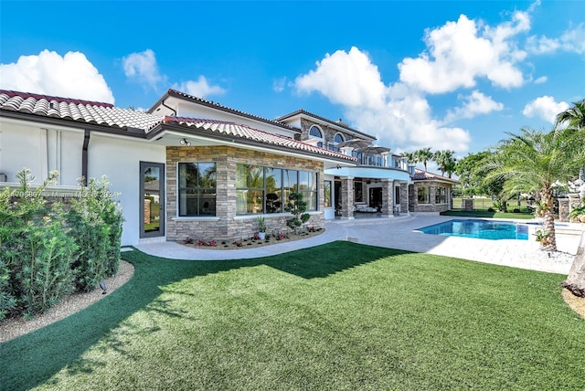 back of property with a yard and a patio