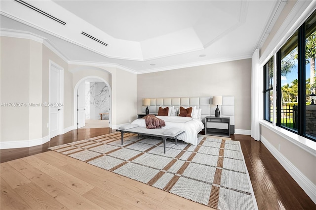 bedroom with a raised ceiling, crown molding, and dark hardwood / wood-style flooring