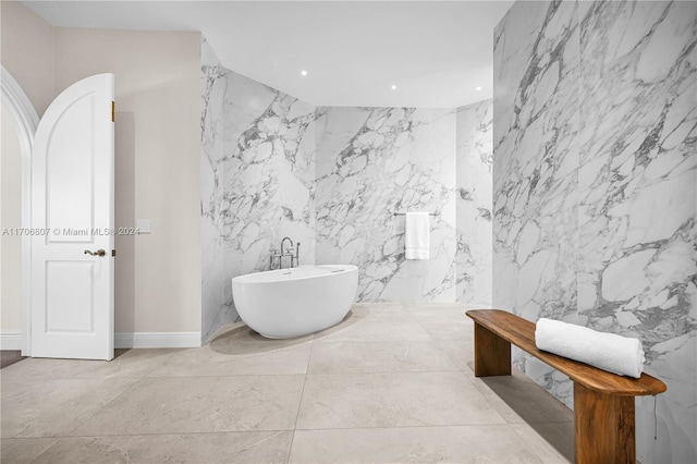 bathroom with a washtub and tile walls