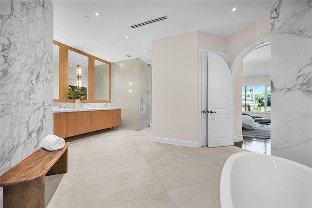 bathroom featuring shower with separate bathtub, vanity, and tile walls