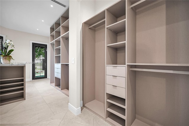 walk in closet with light tile patterned floors