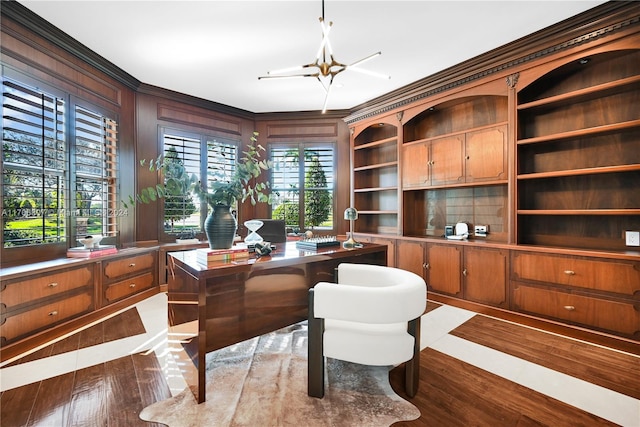 office space featuring a chandelier, built in features, ornamental molding, and wood walls