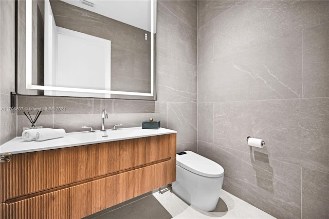 bathroom featuring tile patterned floors, vanity, tile walls, and toilet