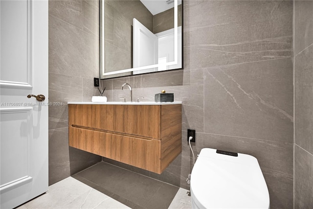 bathroom featuring vanity, toilet, and tile walls