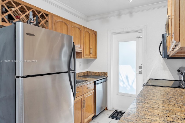 kitchen with appliances with stainless steel finishes, crown molding, and light tile patterned flooring