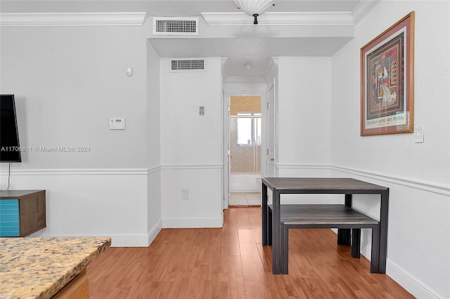 dining area with crown molding and light hardwood / wood-style flooring