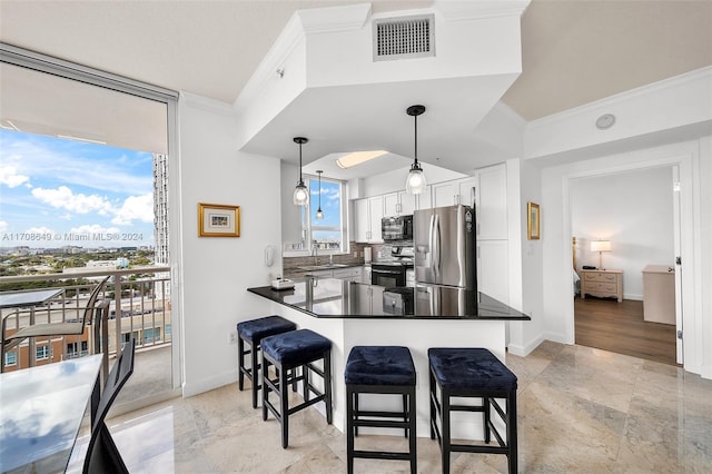 kitchen featuring white cabinets, crown molding, appliances with stainless steel finishes, decorative light fixtures, and kitchen peninsula