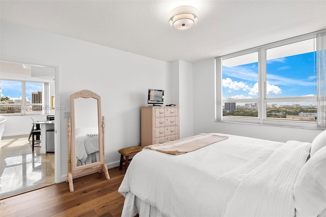 bedroom with hardwood / wood-style flooring and multiple windows