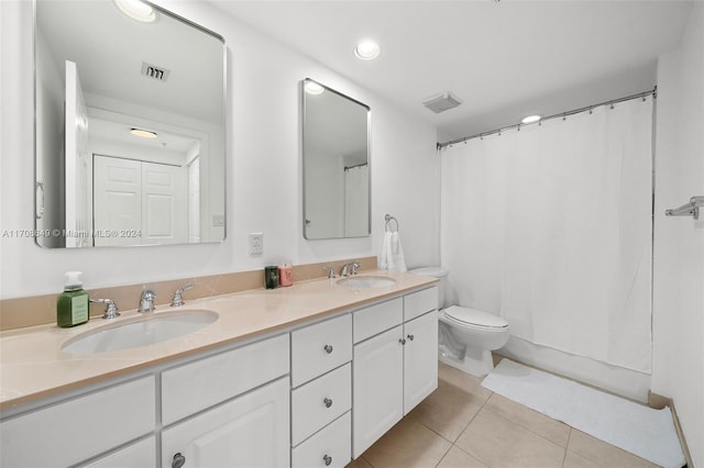 bathroom with toilet, vanity, and tile patterned floors