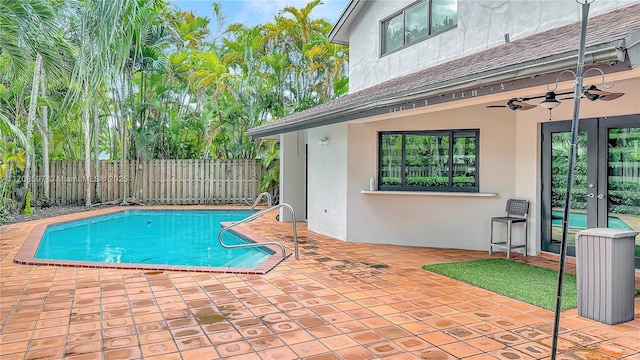 view of swimming pool featuring a patio, ceiling fan, and french doors