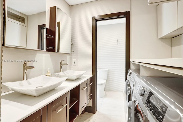 bathroom featuring separate washer and dryer, vanity, tile patterned floors, and toilet