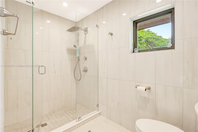 bathroom with a shower with door and toilet