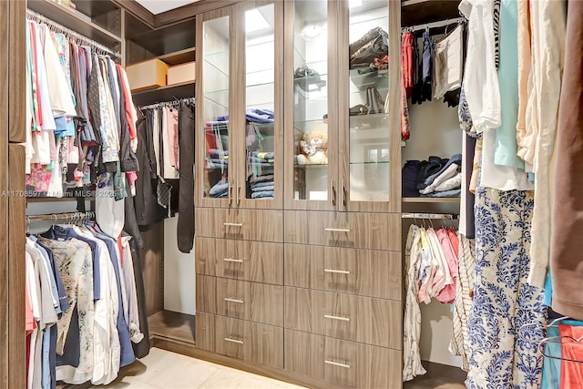 walk in closet with light tile patterned floors