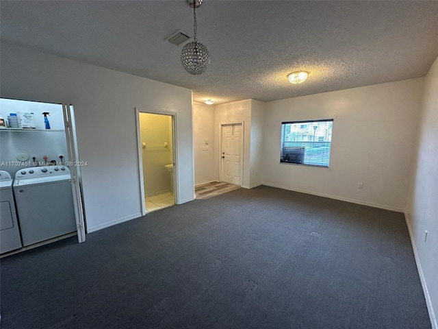 unfurnished bedroom featuring separate washer and dryer, a textured ceiling, and dark colored carpet