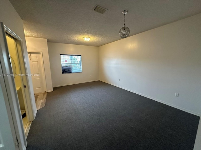 carpeted spare room featuring a textured ceiling