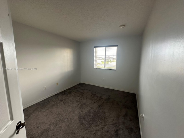 carpeted spare room with a textured ceiling