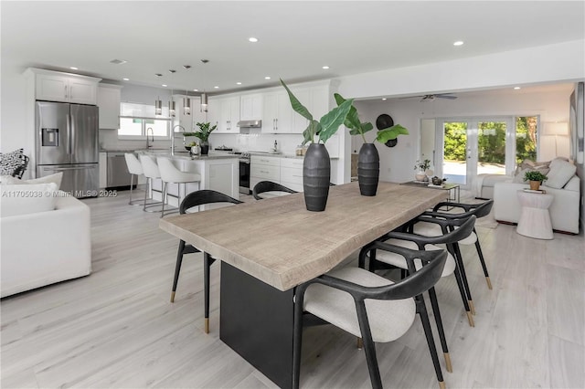 dining area with ceiling fan, light hardwood / wood-style flooring, and sink