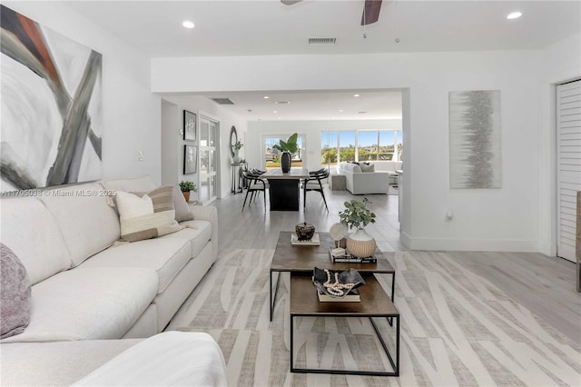 living room featuring ceiling fan and light hardwood / wood-style flooring