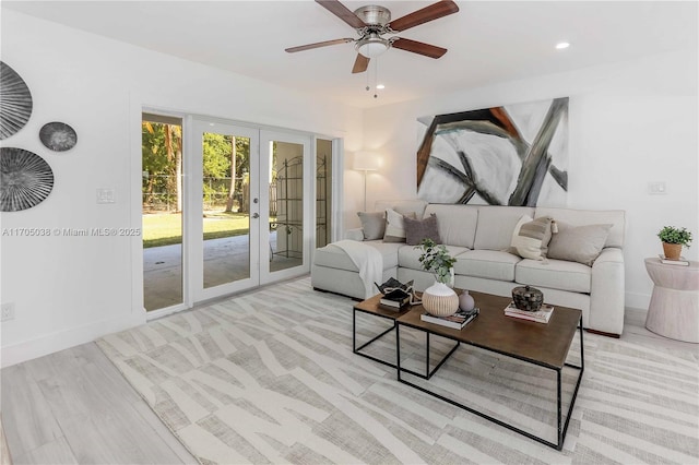 living room featuring ceiling fan, french doors, and light hardwood / wood-style floors