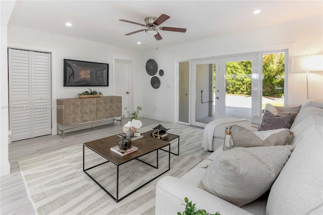 living room featuring ceiling fan, french doors, and light wood-type flooring