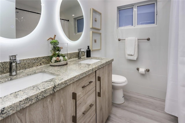 bathroom with hardwood / wood-style floors, vanity, and toilet