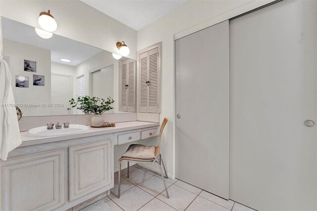 bathroom with tile patterned floors, vanity, and a textured ceiling