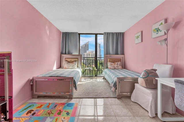 tiled bedroom with access to exterior and a textured ceiling