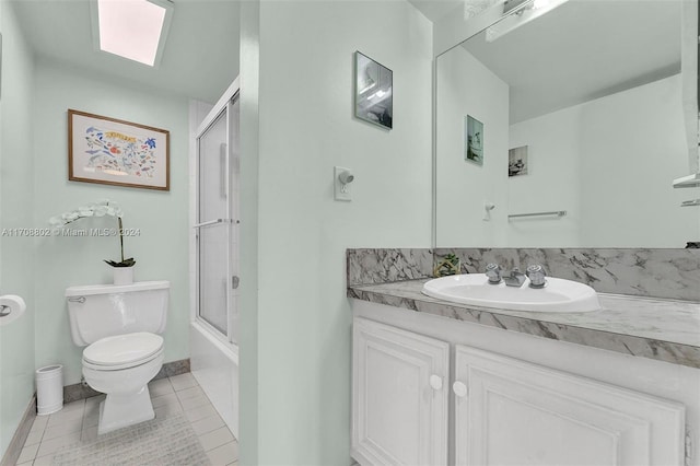 full bathroom featuring shower / bath combination with glass door, vanity, tile patterned floors, and toilet