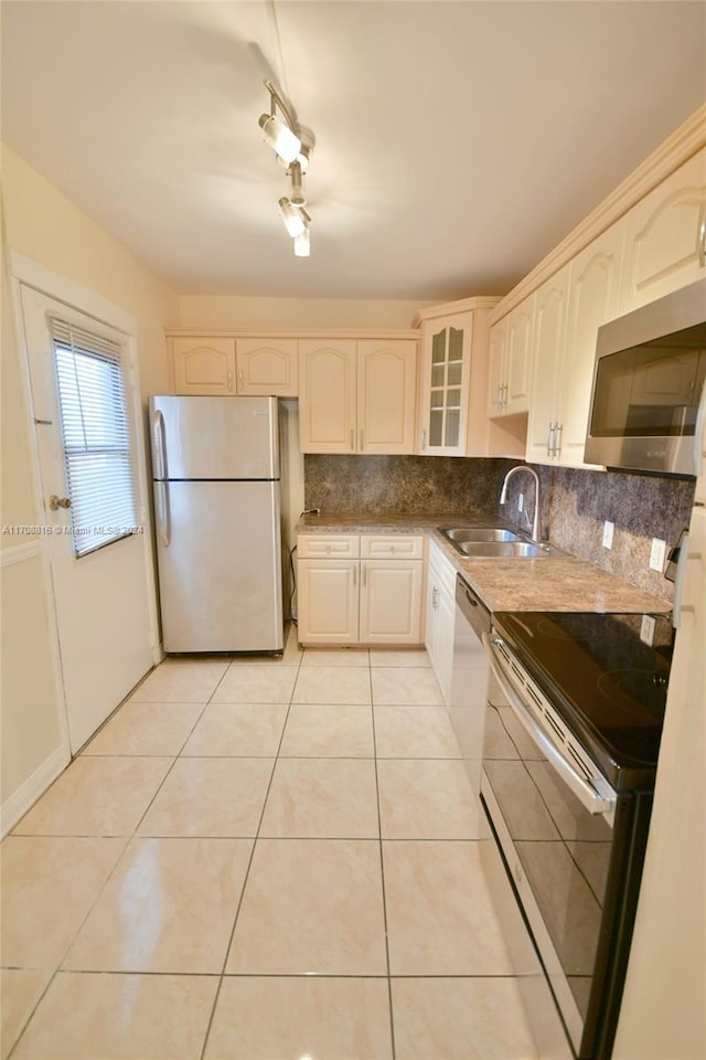 kitchen with white cabinets, sink, light tile patterned floors, and appliances with stainless steel finishes