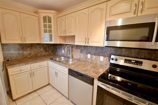 kitchen with backsplash, sink, light tile patterned floors, and appliances with stainless steel finishes