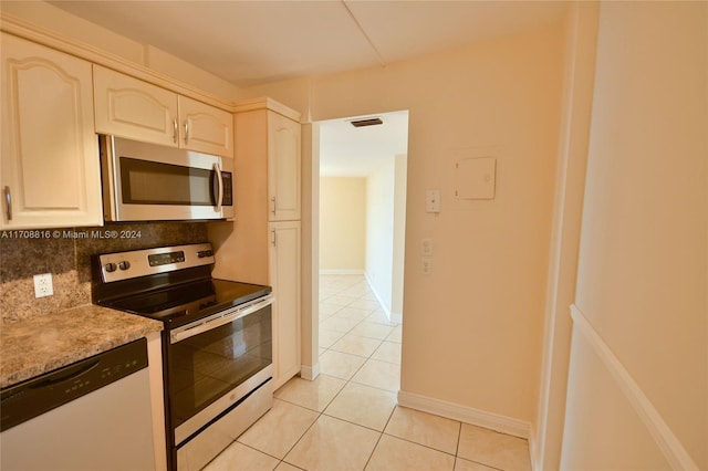 kitchen featuring decorative backsplash, light tile patterned floors, and appliances with stainless steel finishes