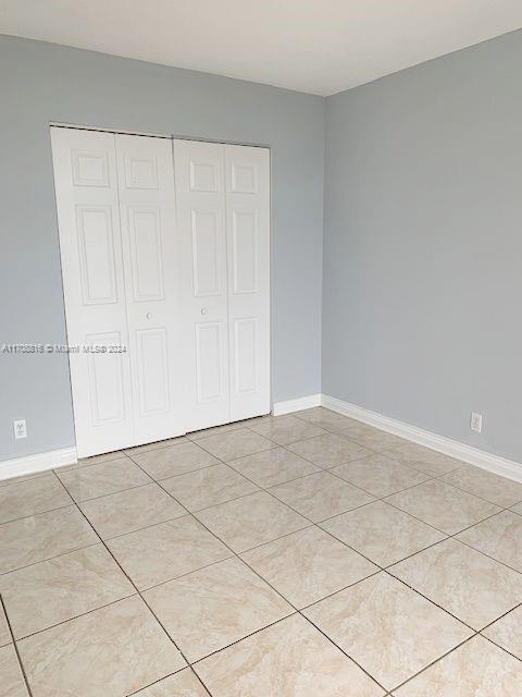 unfurnished bedroom with a closet and light tile patterned flooring