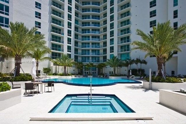 view of pool featuring a patio and a hot tub