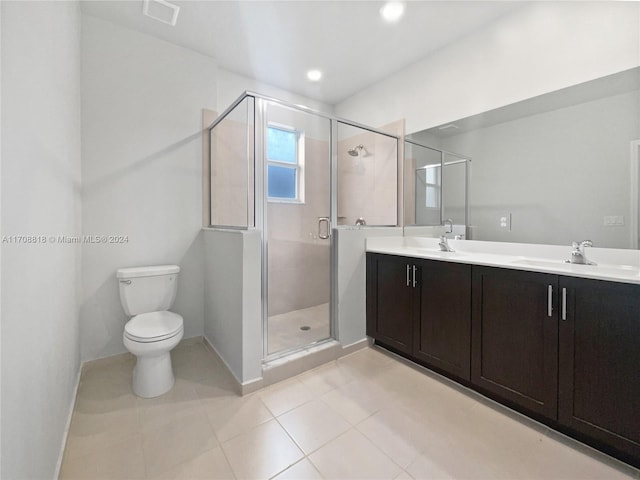 bathroom with tile patterned flooring, vanity, an enclosed shower, and toilet