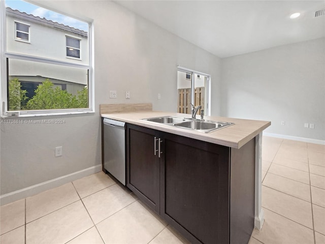 kitchen with dishwasher, sink, light tile patterned floors, dark brown cabinets, and kitchen peninsula