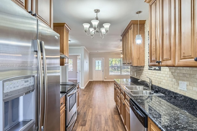 kitchen featuring sink, stainless steel appliances, dark hardwood / wood-style floors, decorative light fixtures, and ornamental molding