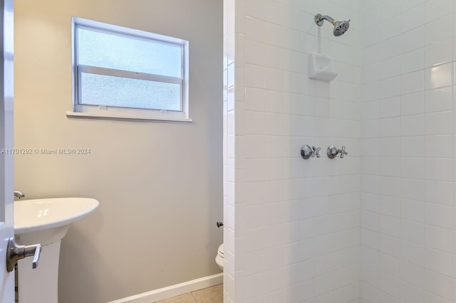 bathroom with a tile shower, tile patterned flooring, and toilet