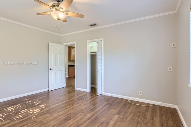 empty room featuring dark hardwood / wood-style floors, ceiling fan, and crown molding