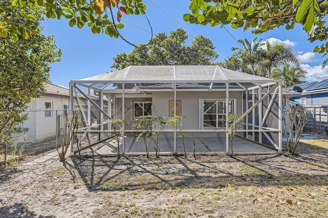 rear view of property with a patio and glass enclosure