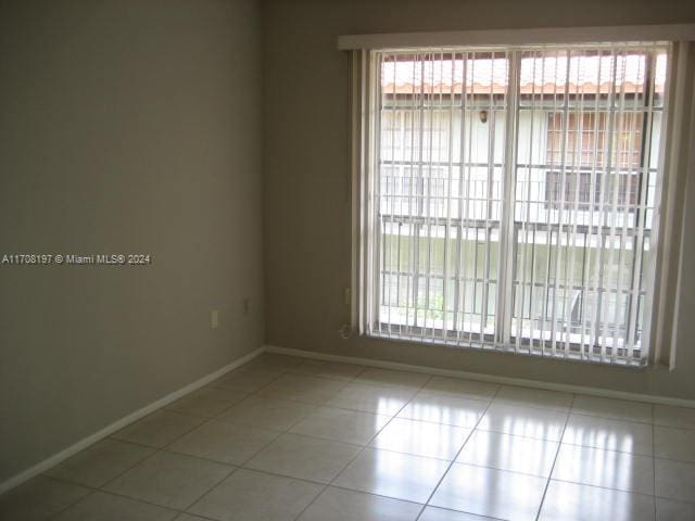 spare room featuring light tile patterned flooring