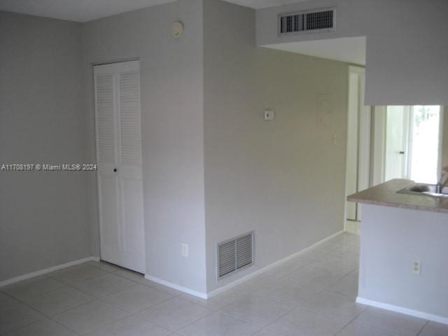 tiled empty room featuring sink