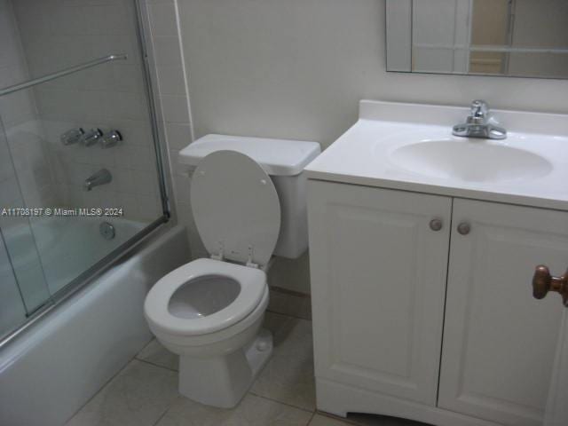 full bathroom with tile patterned flooring, vanity, toilet, and bath / shower combo with glass door