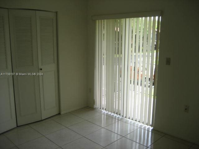 unfurnished bedroom with light tile patterned flooring and a closet