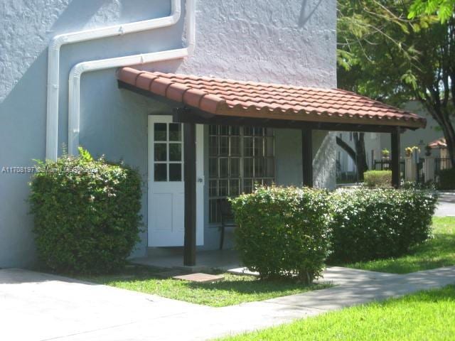10776 N Kendall Dr Unit F-16, Miami, FL 33176 - view of exterior entry featuring stucco siding and a tile roof