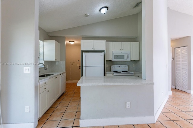 kitchen featuring white appliances, vaulted ceiling, sink, white cabinetry, and light tile patterned flooring