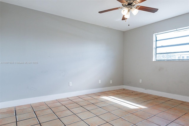 empty room with ceiling fan and light tile patterned floors