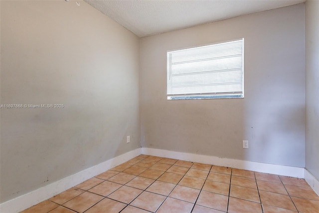 unfurnished room featuring lofted ceiling and light tile patterned flooring