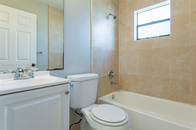 full bathroom featuring tiled shower / bath combo, toilet, and vanity