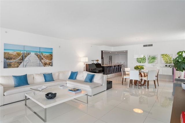 tiled living room featuring a sink and visible vents