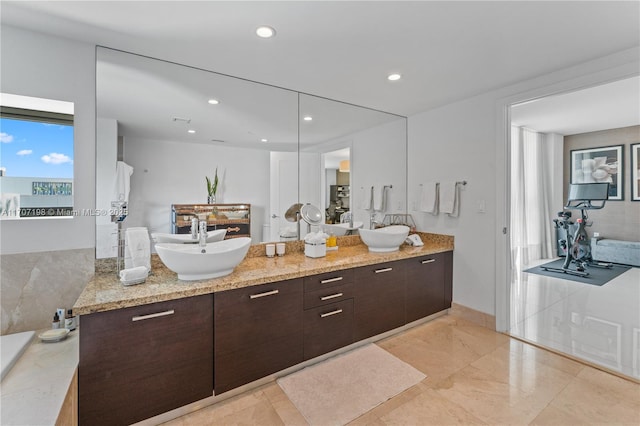 full bath with a sink, recessed lighting, and double vanity